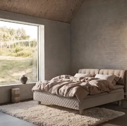 Bed with quilted fabric headboard by Duxiana