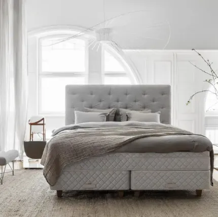Bed with a Royal upholstered and quilted headboard by Duxiana